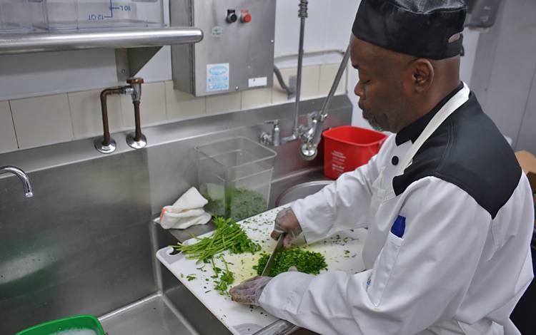 Vernon Dunnegan, lead production worker for Duke Dining Services, chops parsley on Friday morning for Duke’s Zero Waste Picnic. 