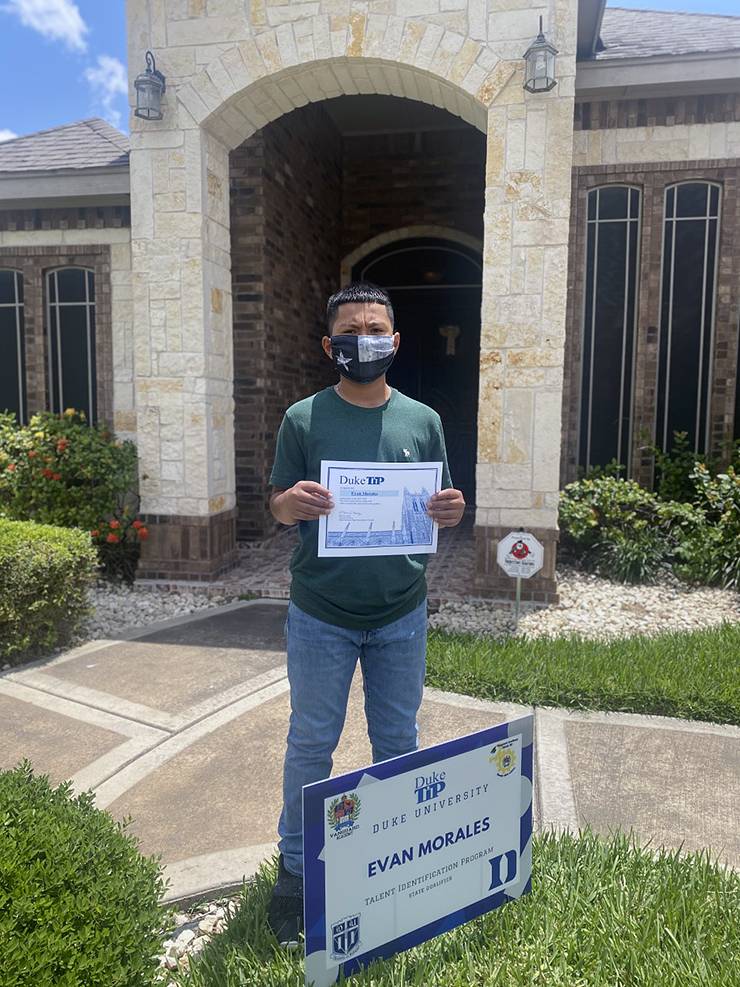 A students standing in front of his house.