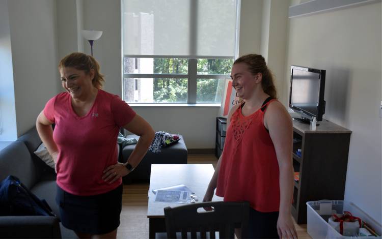 Senior Victoria Johnson, right, and her mother, Michelle, share a laugh in Victoria's living room in the Hollows Quad. Photo by Jonathan Black.