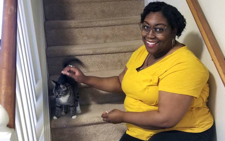Jannice Stratton eases her stress by petting one of her cats, Gumdrop, on the stairs. Photo courtesy of Jannice Stratton.