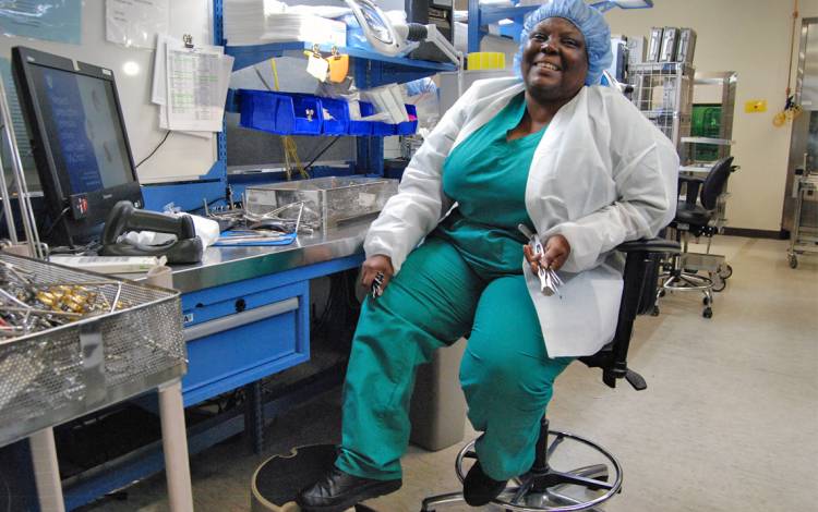 Jean Gregory shows off the shoes she only wears while working in Duke University Hospital's sterile processing units. Photo by Stephen Schramm.
