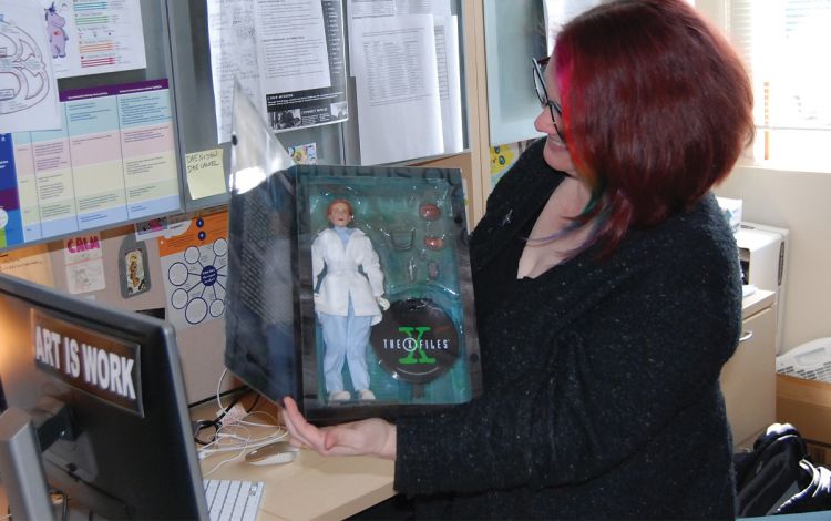Jules Odendahl-James shows off the Dana Scully Barbie that sits above her desk in her office. Photo by Jack Frederick.