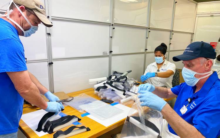 Duke Health Engineering & Operations Team members work together to assemble protective face shields for front-line caregivers. Photo courtesy of Duke Health Engineering & Operations.