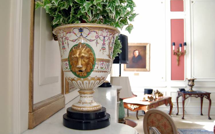 The Pink Parlor features shelves filled with antiques vases and artwork.