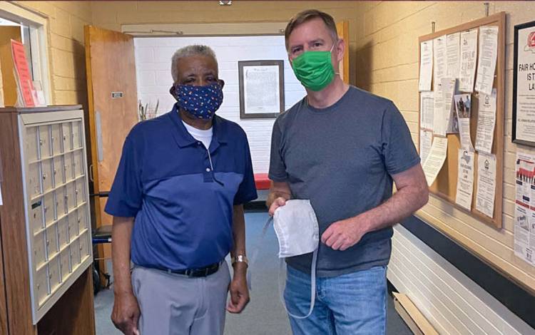 Eric Westman, right, a physician at the Duke Outpatient Clinic and founder of Covering the Triangle, makes a delivery to Willie Patterson, staff member at a Crest Street neighborhood senior home. Photo by Sam Miglarese.