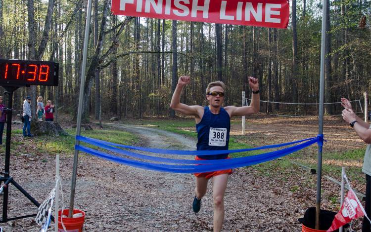 A runner finishes the Pine Cone Pacer.