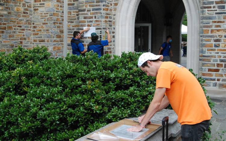 A crew from Overstreet Sign Contractors works to prepare a new plaque for placement on West Campus. 