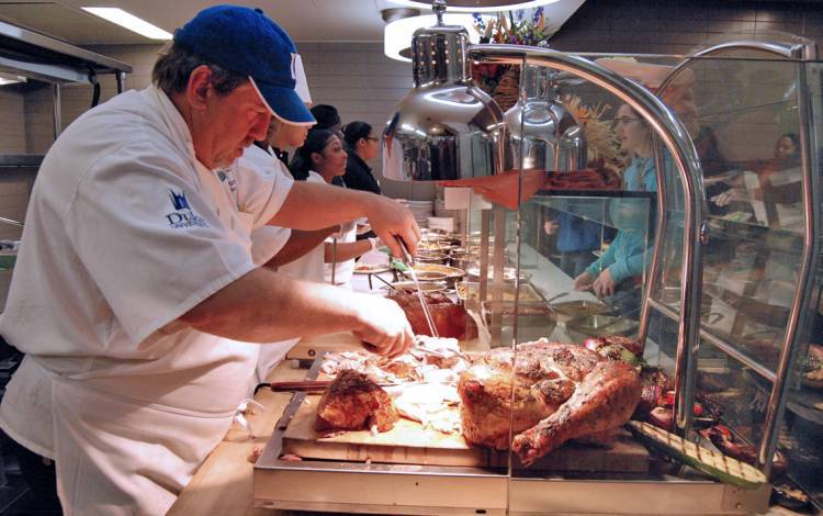 Executive Sous Chef Todd Dumke serves turkey during Duke Dining's Thanksgiving meal in 2019. Photo by Stephen Schramm.