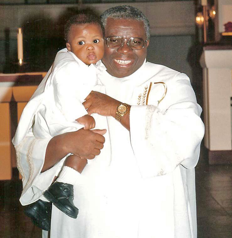 Omoviekovwa Nakireru holds a small child after a baptism. Photo courtesy of Omoviekovwa Nakireru.