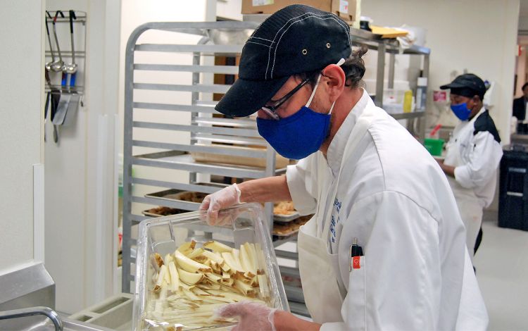 Freeman Center chef manager Eduardo Polit prepares french fries for dinner at the dining facility. Photo by Jack Frederick.