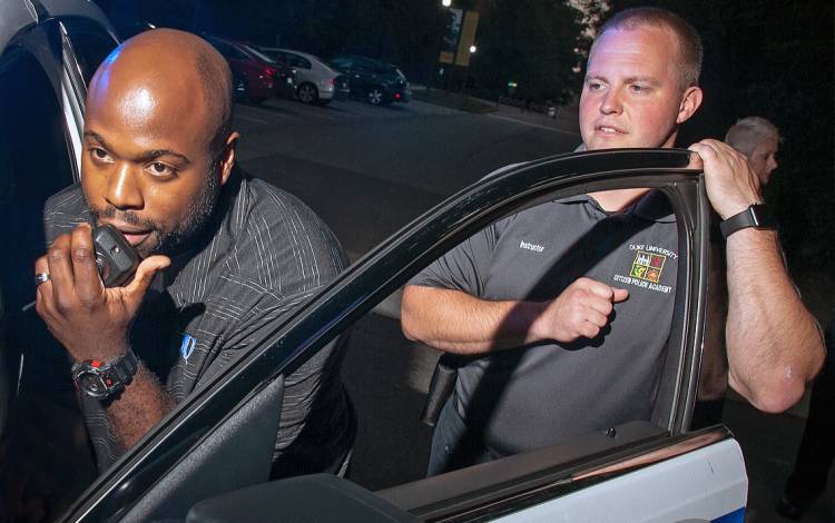 Cortney Hatchell, left, takes part in an exercise during the Duke Citizens Police Academy as Duke University Police Officer Aaron Pruka watches.