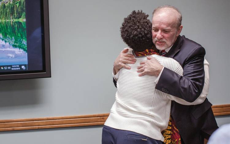 Blaine Paxton Hall, then associate professor for the Department of Community and Family Medicine, hugs a coworker after a presentation he gave last year on caring for transgender patients. Photo by Justin Cook.