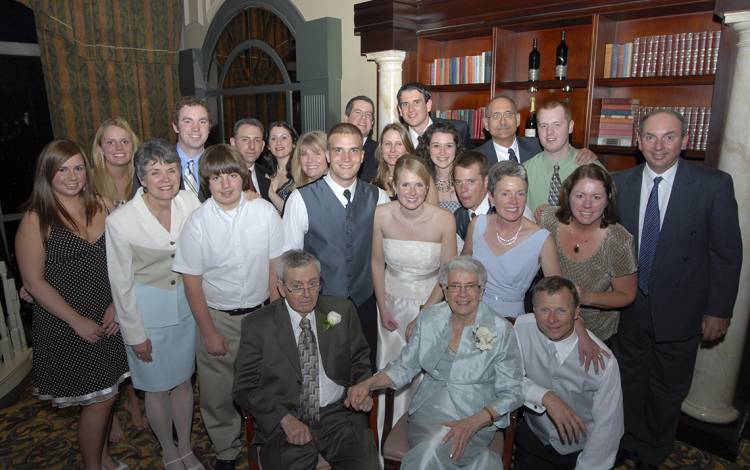 Laura and Josh Howes, center, surrounded by family at their wedding. 