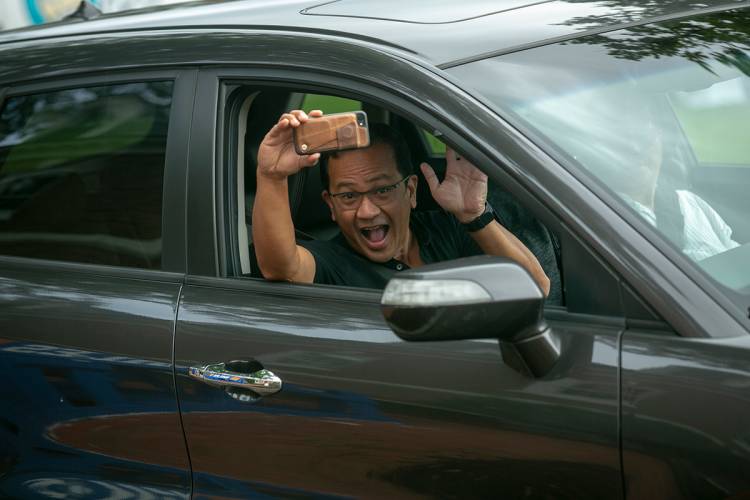 A parent captures the moment they pull up to the residence hall on his smart phone.