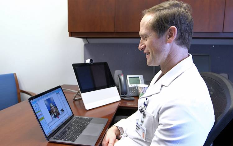 Associate Professor of Orthopaedic Surgery Richard Mather demonstrates a virtual visit prior to the pandemic. Photo courtesy of Duke Health.