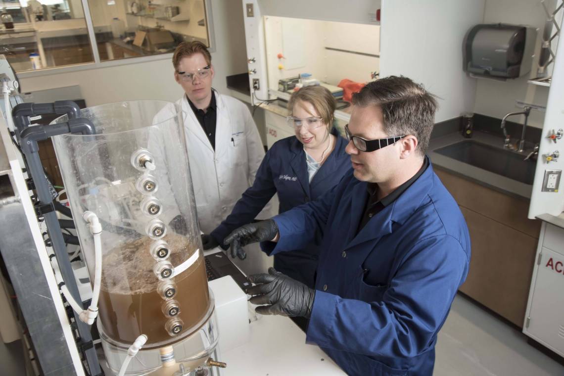 Researchers Brian Hawkins, Katelyn Sellgren, and James Thostenson work together at the Center for WaSH-AID housed in Duke's Chesterfield Building lab space