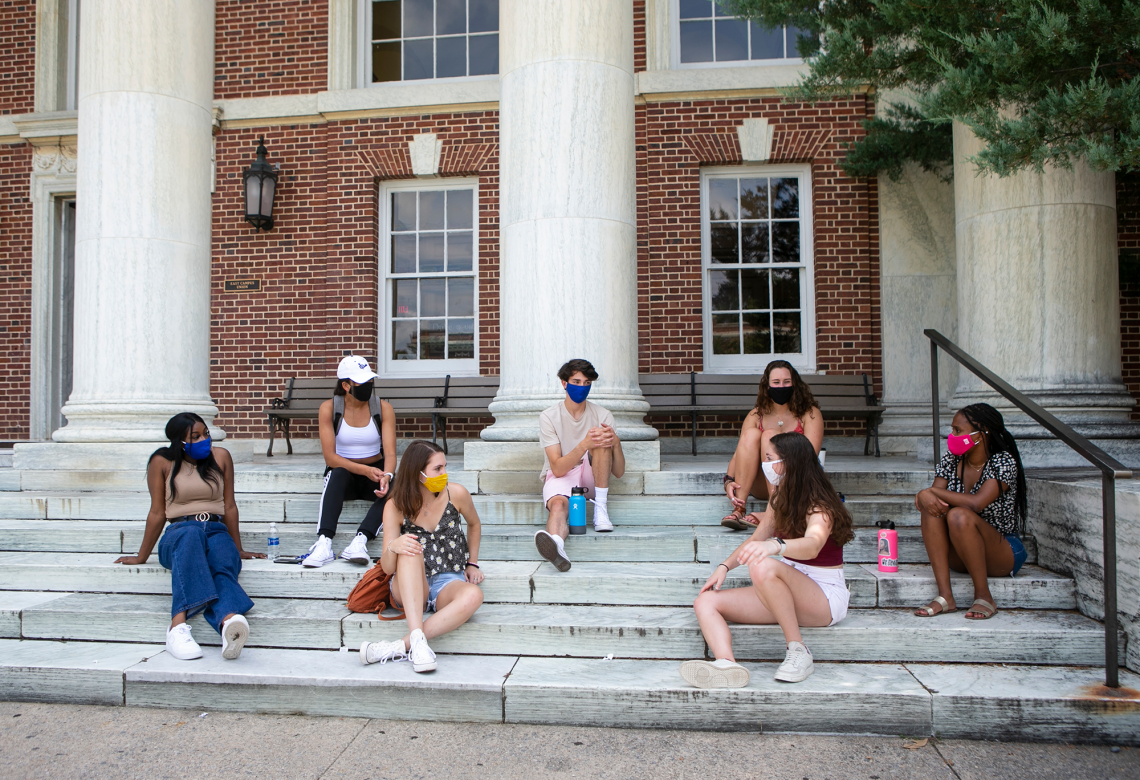 Residential students sit on the steps of East Union on East Campus. Student voices played a valuable role in reconfiguring campus housing for the pandemic.
