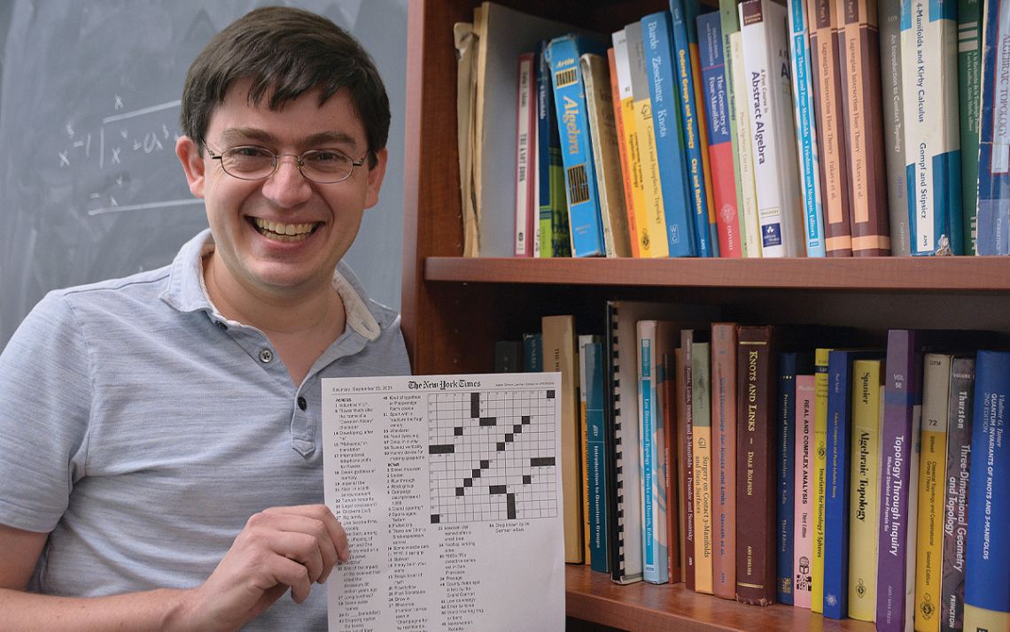 Adam Levine, associate professor in the Duke University Department of Mathematics, holds the crossword puzzle he created for The New York Times. Photos by Stephen Schramm.