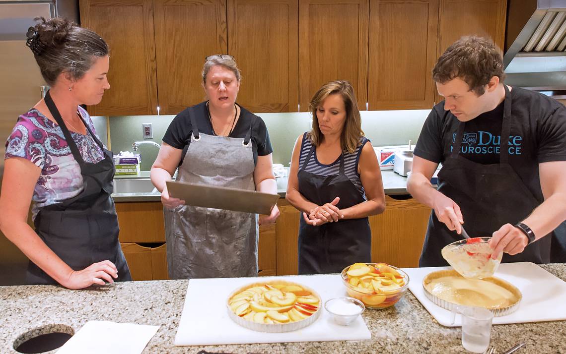 Nicole Schramm-Sapyta, far left, and Duke Institute for Brain Sciences team members cook together at Southern Season.