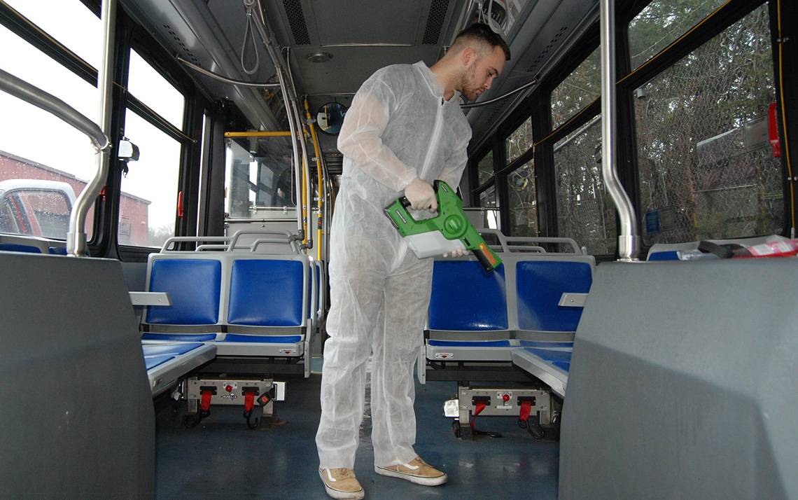 Luke Fenlon of Cenplex Building Services disinfects a Duke bus. Photo by Stephen Schramm.