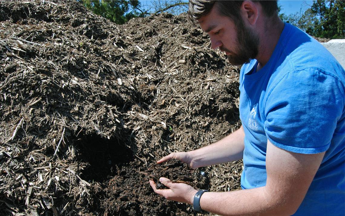 Nick Schwab shows off decaying plant matter from inside a compost pile at Sarah P. Duke Gardens. Photo by Stephen Schramm.