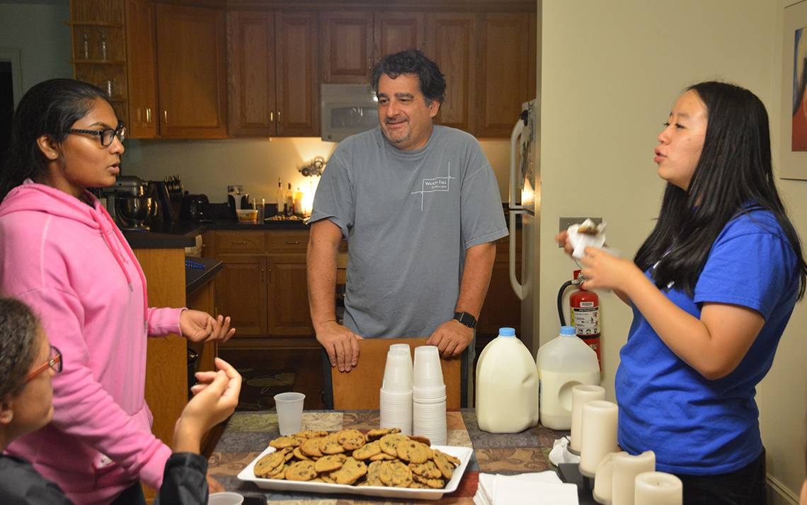 Christopher Roy, center, speaks to first-year students at his weekly cookie night in Wilson Residence Hall. 