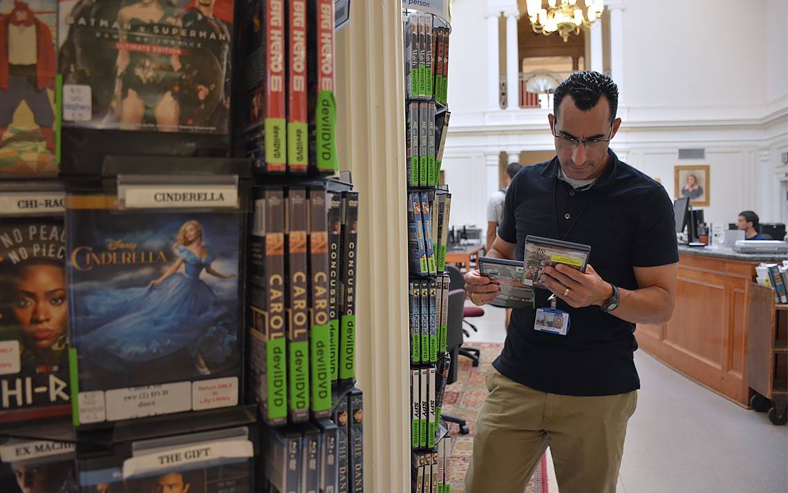 Duke photographer Jared Lazarus peruses the selection of DVDs at Lilly Library on East Campus.