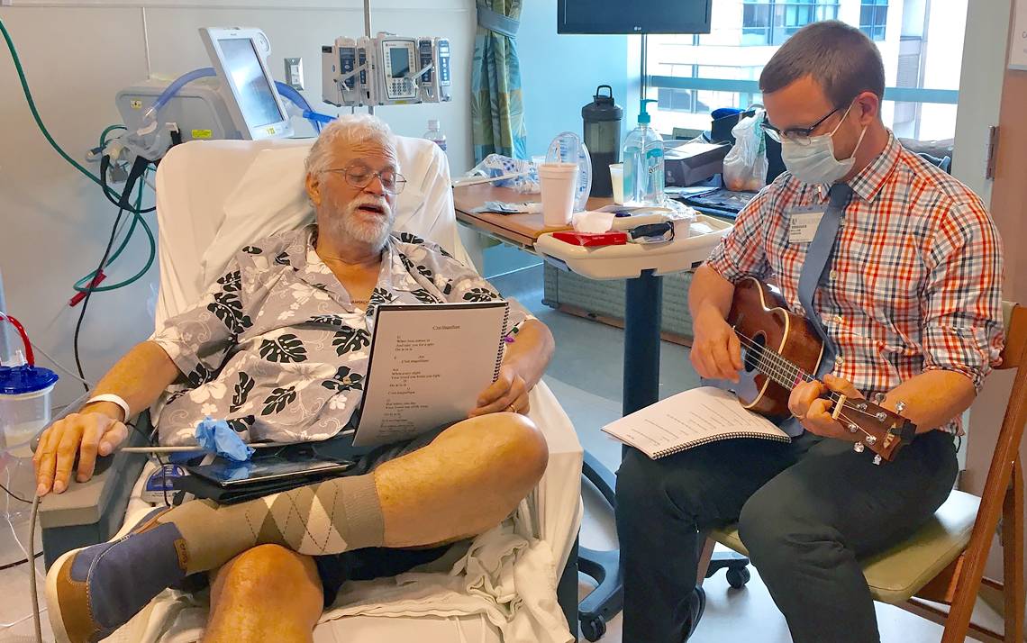 William Dawson, right, of Arts & Health at Duke, plays a ukulele for Duke University Hospital patient David Stucker. Photo courtesy of David Stucker's family.
