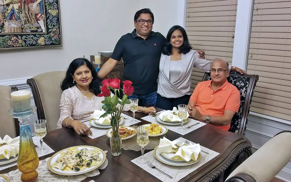 Dinesh Divakaran stands with his wife, Smrithi, at a family dinner with his mom, Devi, left, and father, C.P., right. Photo courtesy of Dinesh Divakaran.