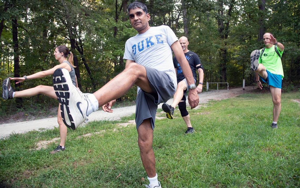 Employees with the Duke Run/Walk Club stretch before a run on the Al Buehler Trail. Photos by Les Todd.