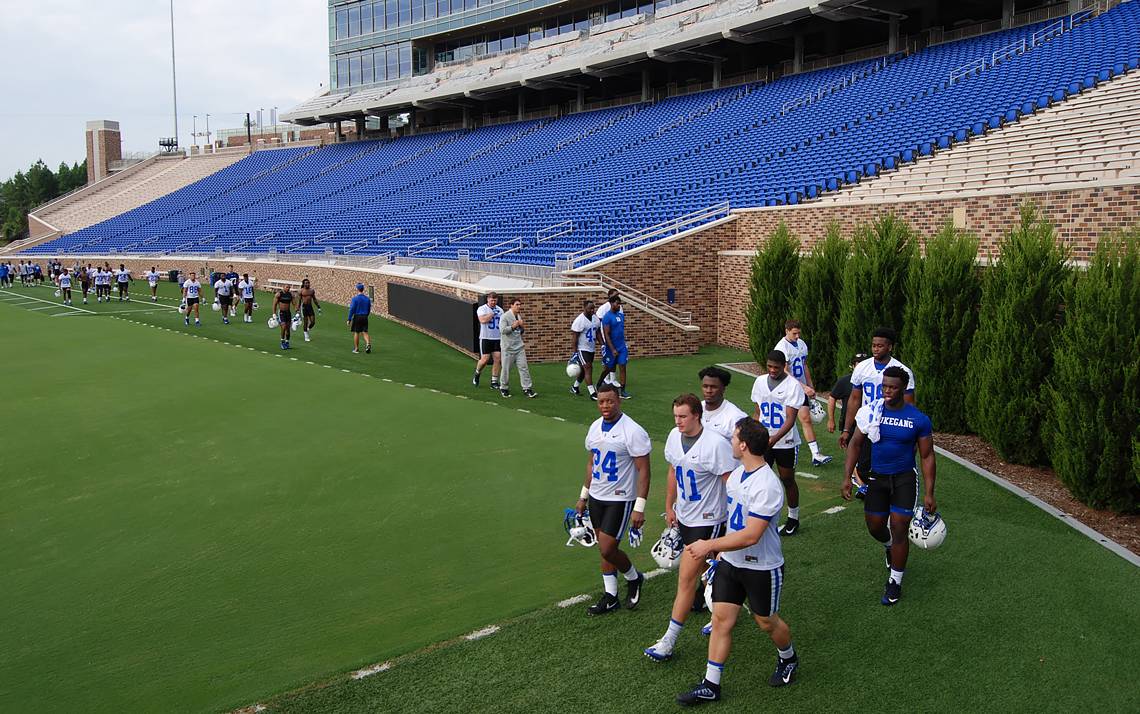 Duke football players take the long route from the practice field to the locker room in order to stay off the playing surface of Brooks Field at Wallace Wade Stadium.