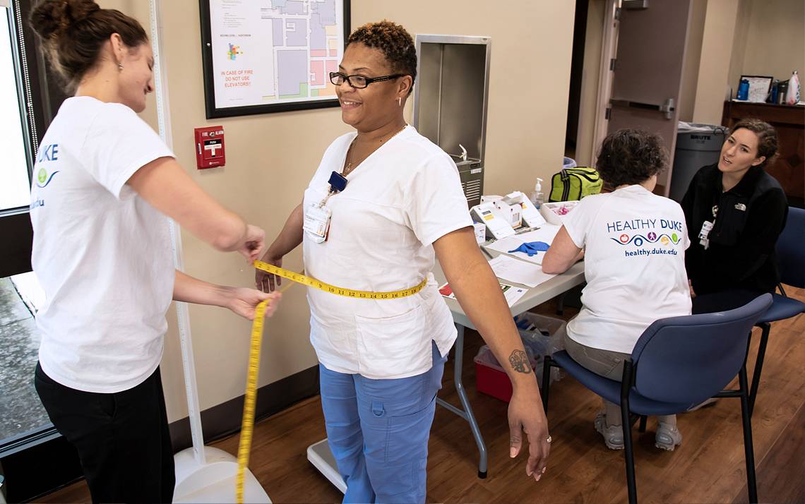 Victoria Hall, left, a certified medical assistant, measures Elizabeth Street’s waist size during a health assessment at Duke Regional Hospital. Photo by Les Todd.