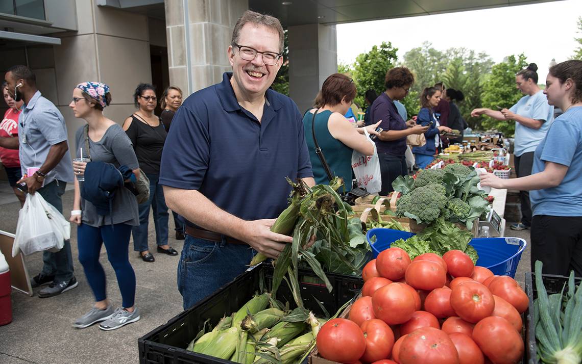 John Ervin shops at the Lyon Farms stand at Duke Farmers Market. Photo by Les Todd.