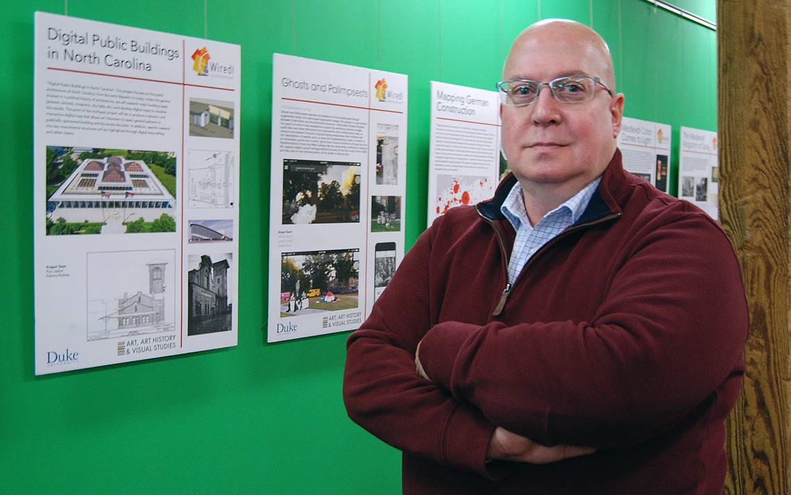 John Taormina standing in front of a green wall.