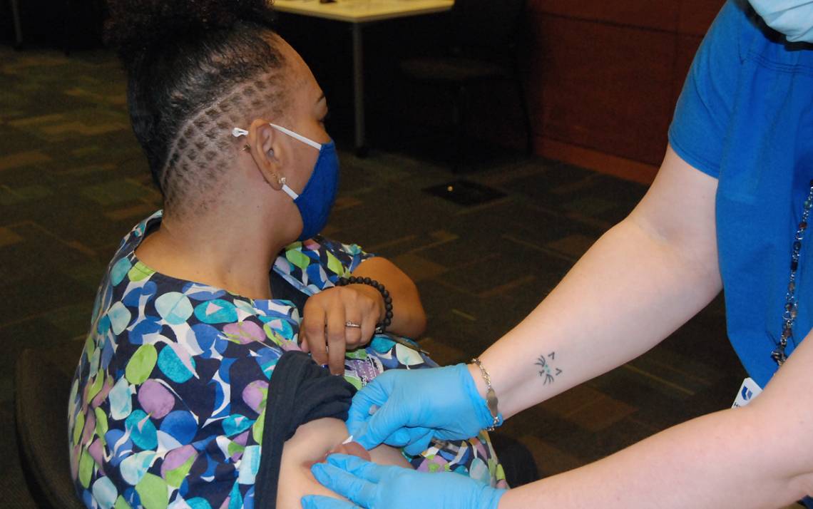 Margaret Bittle, a Duke University housekeeper, receives her first dose of the COVID-19 vaccine last week. Photo by Stephen Schramm.