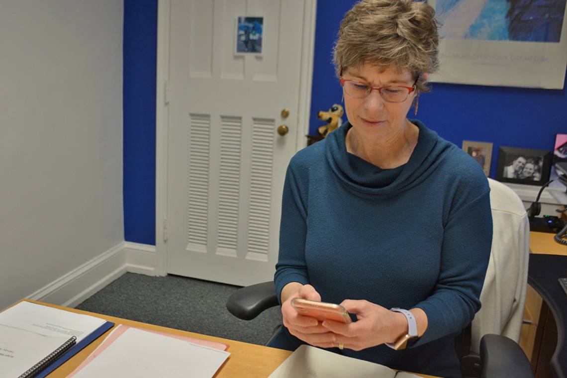 Mary Greenway, executive assistant to Provost Sally Kornbluth, works from her cellphone in her office in February. Photo by Jonathan Black.