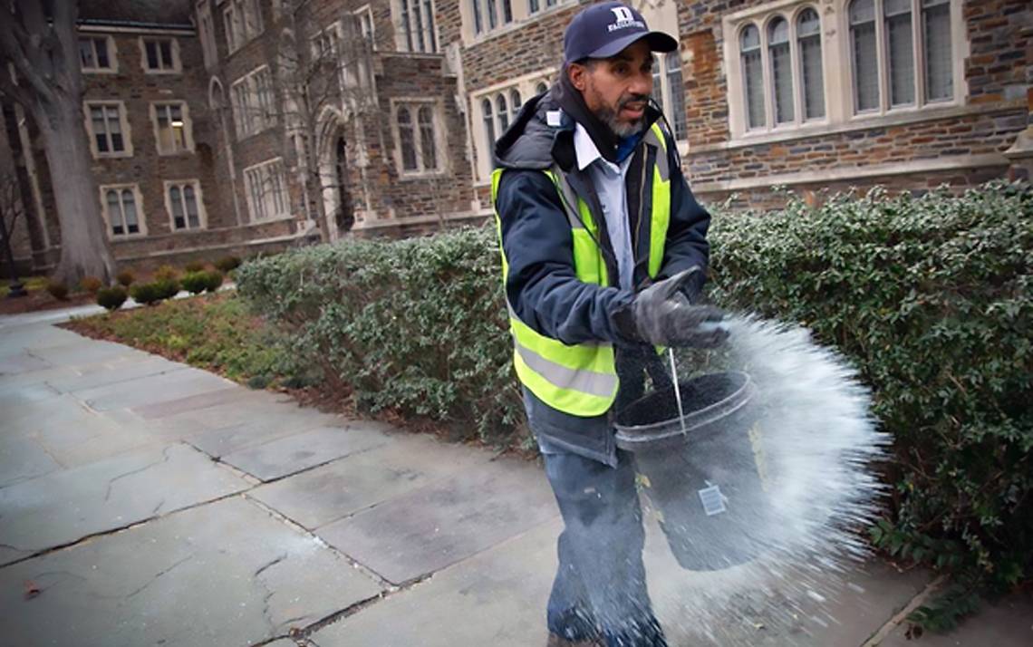 Elvis Holden, a Facilities Management Department landscape specialist, spreads ice melt in front of the Old Chemistry Building on Friday morning. Photo by Jared Lazarus/Duke Photography