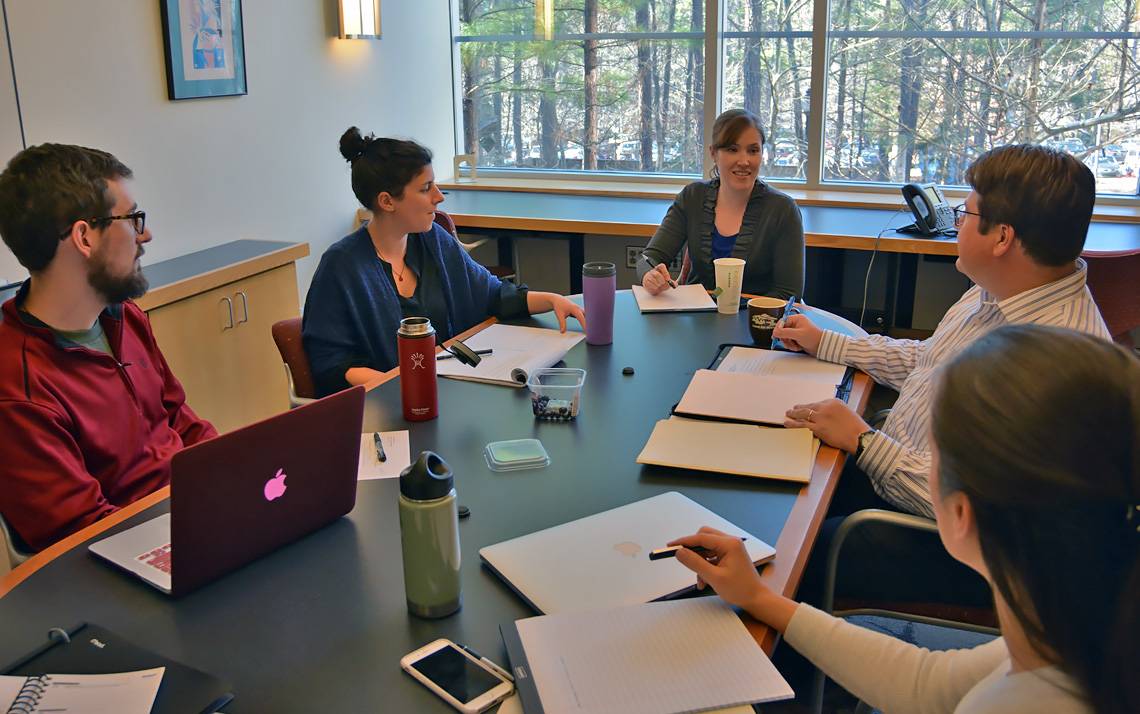 Shannon Arata, at the far end of the table, meets with law and graduate students who work as a legal case team.