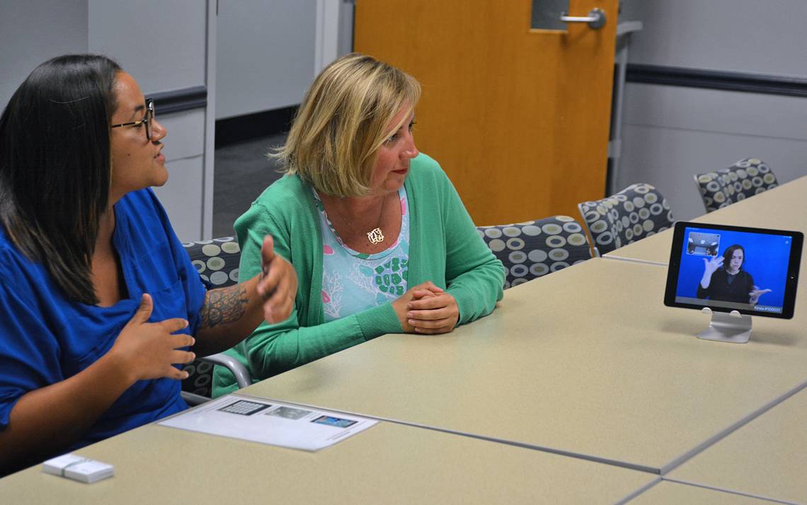 Nicole Stovall, assistive technology and case management coordinator for Duke Disability Management, and Leigh Fickling, director of Disability Management, use American Sign Language to communicate with a Stratus translator.  Photo by Jonathan Black.