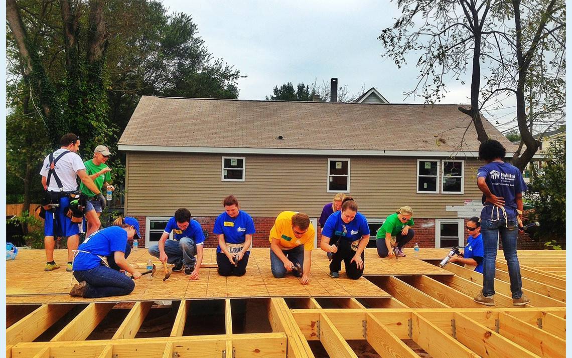 Duke Development employees volunteered last year with Habitat for Humanity of Durham. Volunteers completed flooring, window framing and duct work. Photo courtesy of the Duke Office of Durham and Regional Affairs / Duke Development
