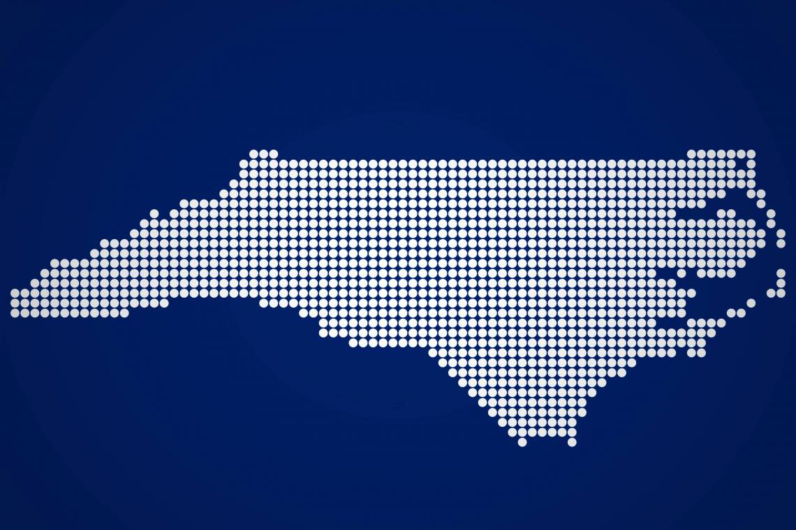 White outline of the state of North Carolina on a dark blue background.