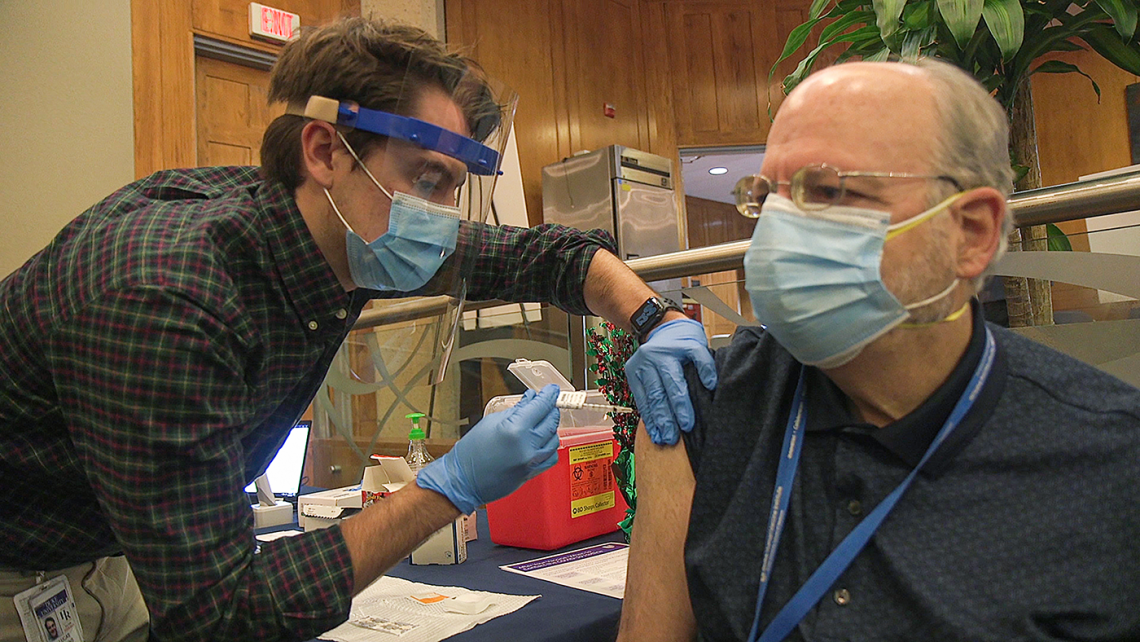 Dr. Barton Haynes receives his first dosage of the COVID vaccine.