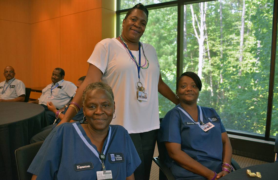 Annie Smith, standing, a senior supervisor for housekeepers at the Fuqua School of Business, poses with Vanessa Bass, left, and Beverly Jordan, housekeeper specialists at the school. The image was taken during 2015’s appreciation lunch.