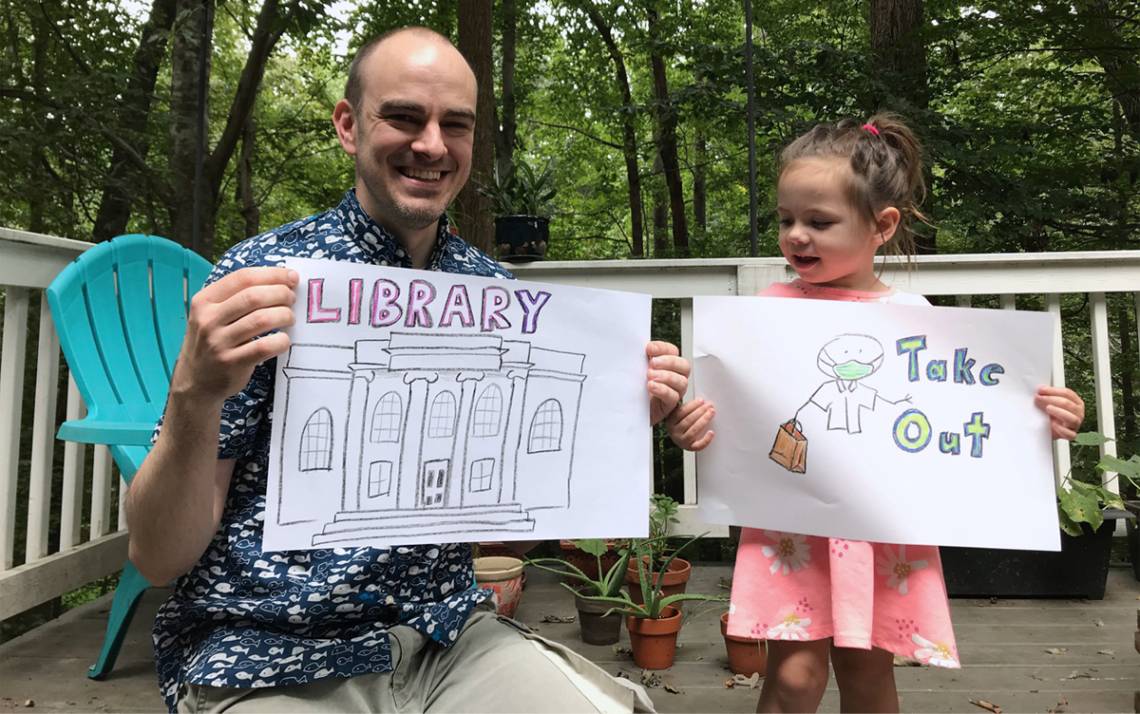 Jamie Keesecker and his daughter Naima hold up drawings used in the Library Takeout video. Photo courtesy of Jamie Keesecker.