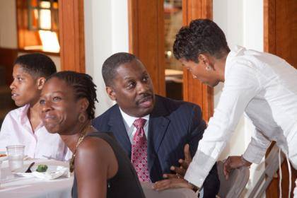 Keynote speaker Thomas LaVeist, middle, talks with panel moderator Rhonda Sharpe at a conference on health disparities. Photo by Les Todd.