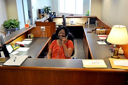 Arnetta Davis greets visitors and answers the phone as a long-time staff specialist at Duke Clinical Research Institute. Photo by April Dudash