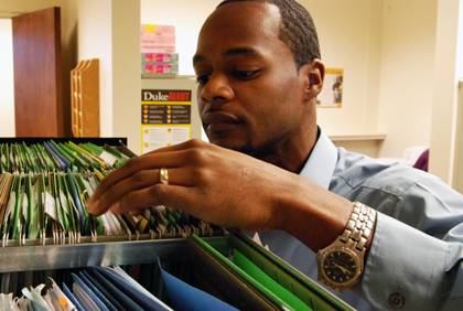 Rodney Coffin sifts through grant folders in the Office of Research Support. Photo by Marsha Green.