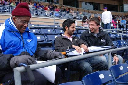 Ben Ward, left, at a Durham Bulls game with students Neil Krishnan and Christopher Tweed-Kent. Photo by Marsha A. Green.