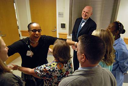 Cheryle Johnson, left in a black shirt, leans in for a hug with coworkers. She said having supportive relationships with colleagues helps her feel encouraged to perform her job well, which she tries to pay forward to others. Photo by Bryan Roth.