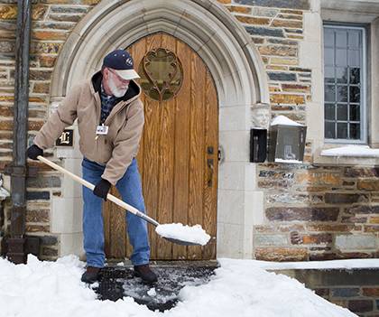 Frank Horner, residential life maintenance supervisor, shovels snow after intense snowfall in February. Photo by Duke Photography.